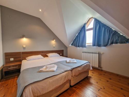 a bedroom with a large bed with blue curtains at Villa Deja Vu Private Jacuzzi & Sauna, Fireplace, 3 Bedrooms, near Bansko in Razlog