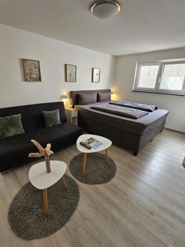 a bedroom with a bed and a couch and a table at Ferienwohnung Alina in Rust