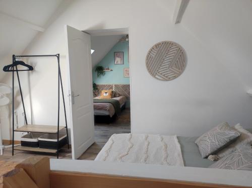 a bedroom with a bed and a room with a couch at Gîte de l'écluse carrée in Coulogne