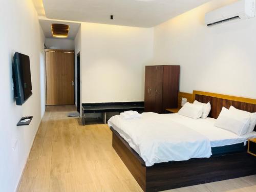 a hotel room with two beds and a television at Origin Suites Luxury Boutique Hotel Pushkar in Pushkar