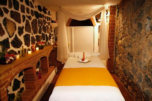 a room with two beds in a brick wall at Wellness Casa Doña Juana in Tepoztlán