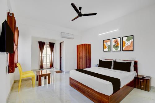 a bedroom with a bed and a yellow chair at Super Hotel O Destiny Inn in Pune