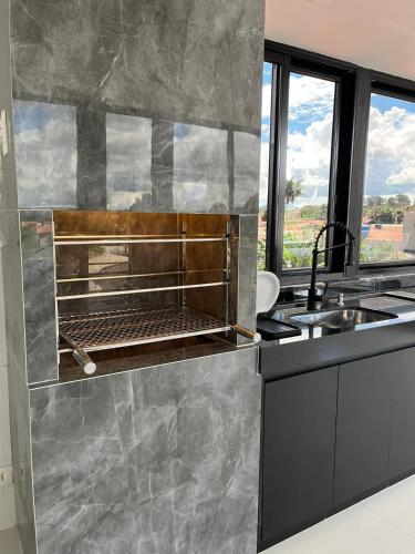 a kitchen with a sink and a counter top at Residencial Canto dos Passarinhos - Loft e Apartamentos in Alto Paraíso de Goiás