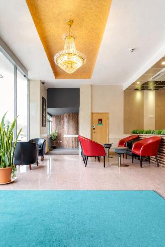 a lobby with red chairs and a chandelier at Eurotraveller Hotel - Premier - Harrow in Harrow