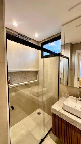 a bathroom with a glass shower and a sink at Apartamento de Luxo 2 Quartos, Brasília - Get Park Sul - com Garagem in Brasília