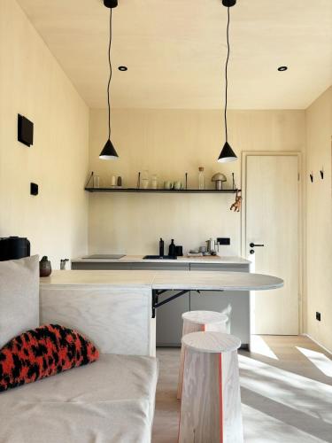 a kitchen with a counter and two stools at Tiny House 1 mit Garten in der Lüneburger Heide in Soltau