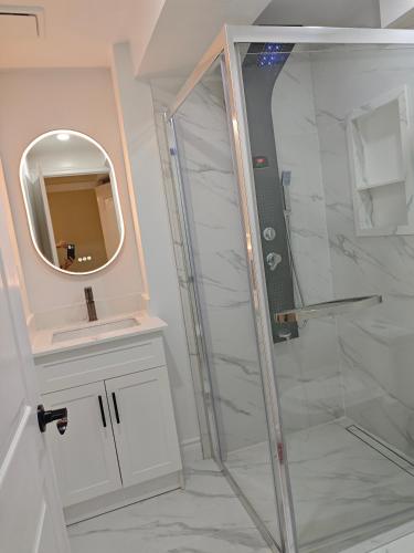 a bathroom with a shower and a mirror at New and Stylish 3BR Private Basement Apartment with 3 Baths & Parking in Richmond Hill