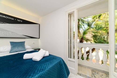a bedroom with a blue bed and a window at Muta House in Sorrento