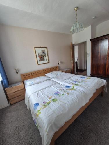 a bedroom with a large white bed with flowers on it at Villa Nusswald in Krumpendorf am Wörthersee