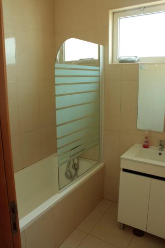 a bathroom with a bath tub and a sink at Flat Mimmo in Praia
