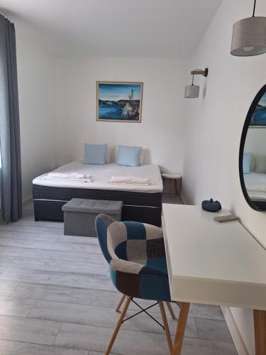 a bedroom with a bed and a table and a chair at Apartment DESi in Balchik