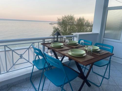 a table and chairs on a balcony with the ocean at michelangela in Ireon