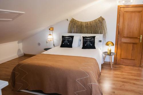 a bedroom with a large bed with two dogs pillows at Chitaka's Organic Farmhouse in Ribatejo in Santo Estêvão