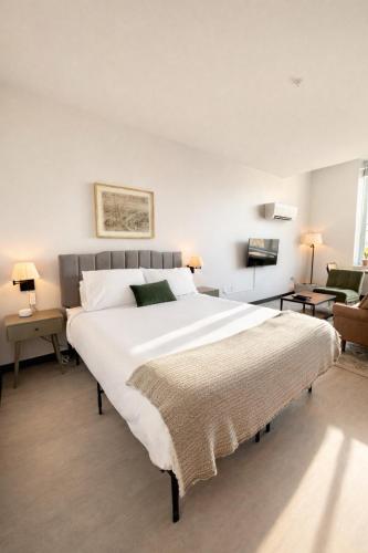 a bedroom with a large white bed and a couch at Deer District Studio Apt - One Block from Fiserv and Baird in Milwaukee