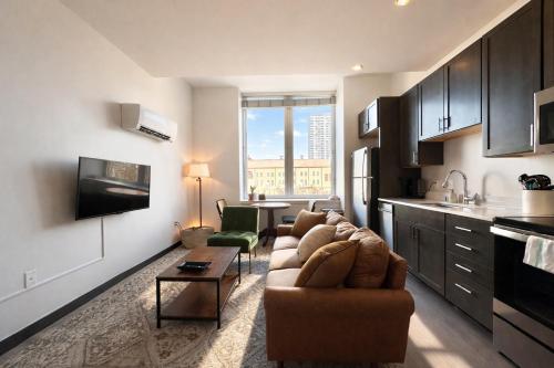 a living room with a couch and a kitchen at Deer District Studio Apt - One Block from Fiserv and Baird in Milwaukee