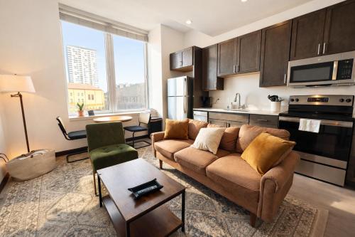 a living room with a couch and a kitchen at Deer District Studio Apt - One Block from Fiserv and Baird in Milwaukee