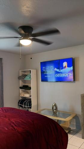 a bedroom with a ceiling fan and a tv on the wall at Cozy Haven your home away from home in Hollywood