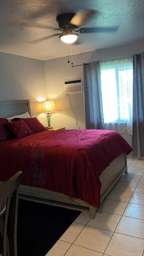 a bedroom with a red bed and a window at Cozy Haven your home away from home in Hollywood