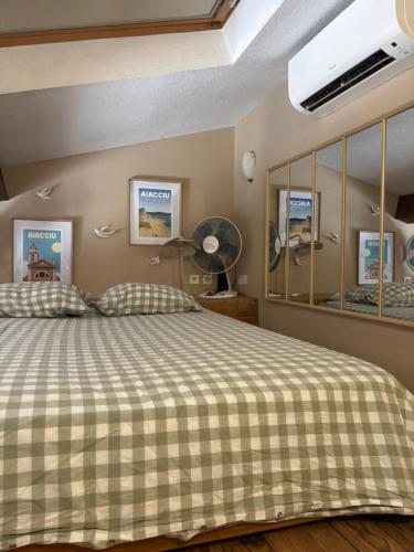 a bedroom with a bed with a checkered blanket at Studio 1er Consul in Ajaccio