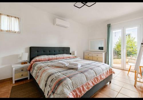 a bedroom with a bed and a tv and a window at Villa Adele Binibeca sea view in Binibeca