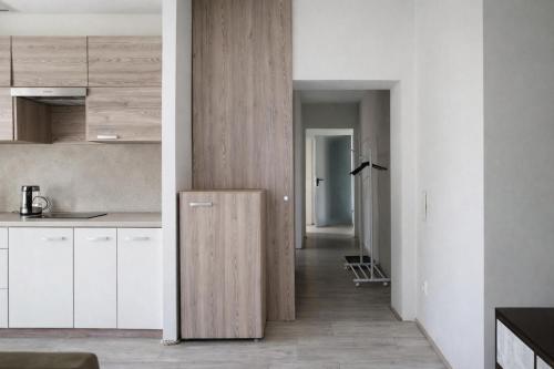 a kitchen with white cabinets and a wooden refrigerator at Apartamenty Doliny in Szczyrk