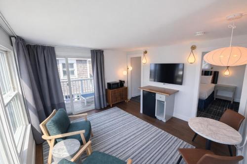 a small living room with a room with a bed and a television at The Foxberry - A Digital Concierge Guesthouse in Provincetown