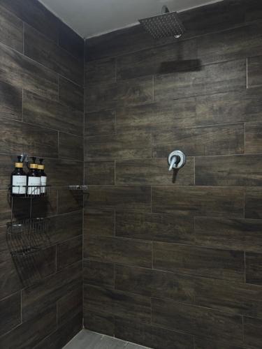 a bathroom with a shower with wooden tiles at Suite Privada Moderna in Santa Ana Chiautempan