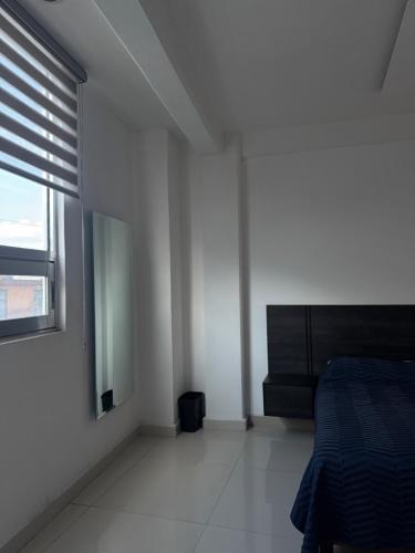 a white bedroom with a bed and a window at Suite Privada Moderna in Santa Ana Chiautempan