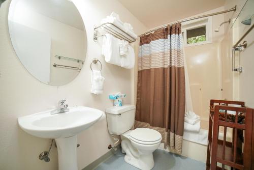 a bathroom with a sink and a toilet and a mirror at Ecola Creek Lodge in Cannon Beach