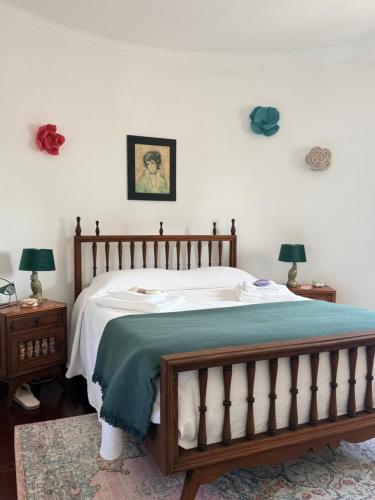 a bedroom with a bed and two night stands with lamps at Moinho da Saudade in Alcabideche