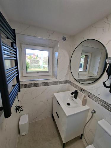 a white bathroom with a sink and a mirror at Pensjonat Krystian in Chmielno
