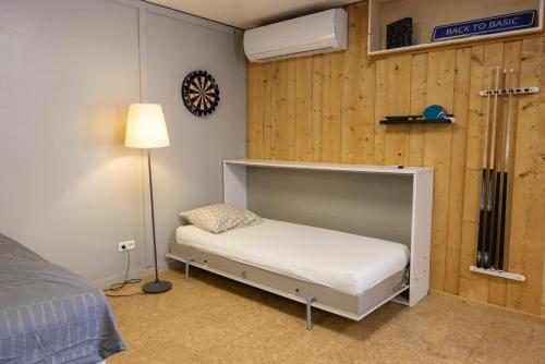 a small bedroom with a bed and a lamp at Studio with Pool Table and Optional Sauna & Hot Tub in Zwaanshoek