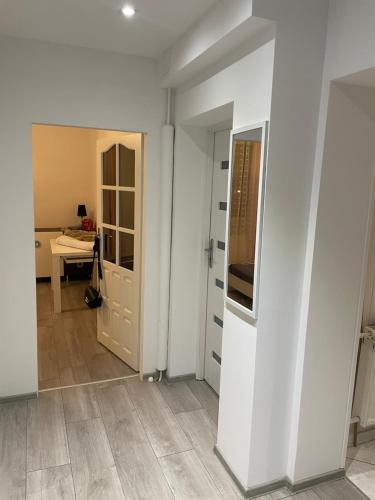 a room with white walls and a hallway with a door at Jak w domu in Słupsk