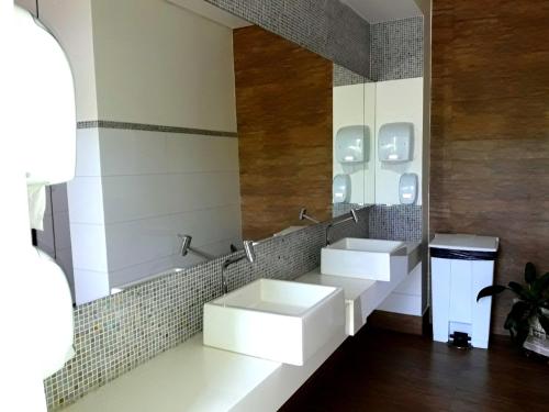 Baño con 2 lavabos y espejo en Hotel Planalto 2, en Governador Valadares