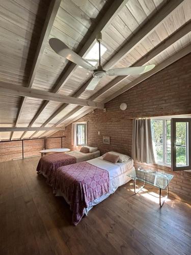 a large bedroom with two beds and a ceiling fan at Duplex Las Margaritas Bosque Peralta Ramos in Mar del Plata