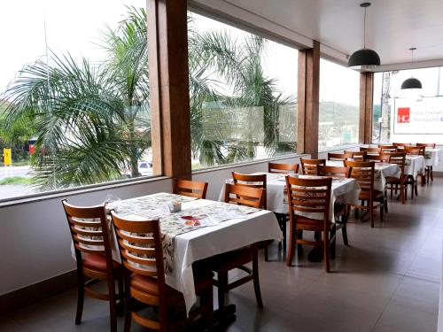 un restaurante con mesas y sillas y una gran ventana en Hotel Planalto 2, en Governador Valadares