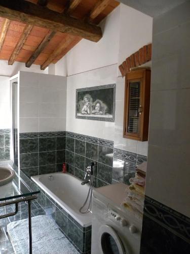 a bathroom with a tub and a washing machine at Casa Tucci in Reggello