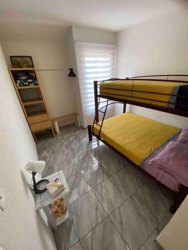 a bedroom with two bunk beds and a table at Mi Casa Modernista cerca del AIFA in Santa Cruz Tecamac