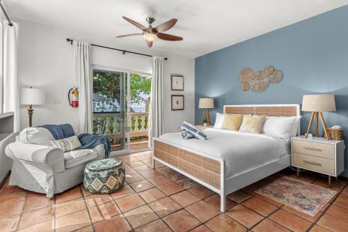 a bedroom with a bed and a couch and a fan at Tres Sirenas Beach Inn in Rincon