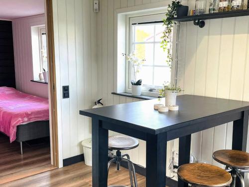 a room with a table and stools and a bed at 4 star holiday home in SÖLVESBORG in Sölvesborg