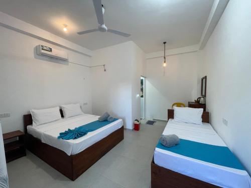 two beds in a room with two beds sidx sidx sidx at LA PRINCE HOTEL and HOSTEL in Trincomalee