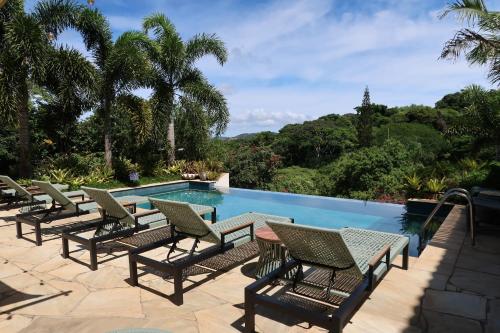 a row of chairs sitting next to a swimming pool at Pousada Villa Canaã in Búzios