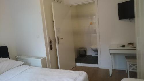 a room with a bed and a bathroom with a toilet at Wellness Suite Utrecht in Utrecht