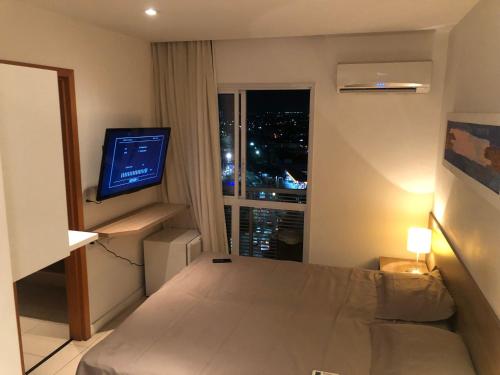 a hotel room with a bed and a television at Aparthotel diamond flat in Nova Iguaçu