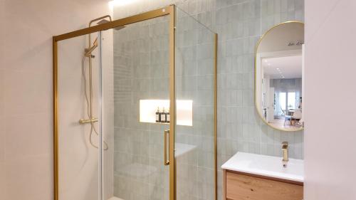 a bathroom with a shower with a sink and a mirror at The Eight Element Suites & Lofts in Madrid
