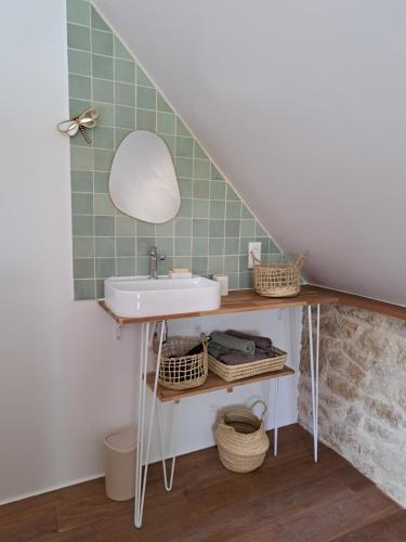 a bathroom with a sink and a mirror at Instant Lot Maison pierre insolite Piscine Nature in Strenquels