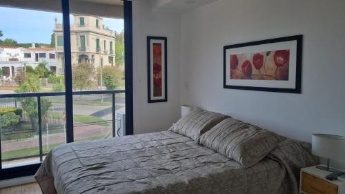 a bedroom with a bed and a large window at Seaside Piriápolis apartamento 105 in Piriápolis