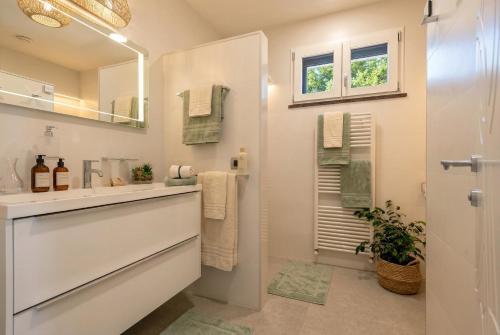 a white bathroom with a sink and a mirror at Luxury Sunshine Villa in Alghero with pool and sea view in Alghero