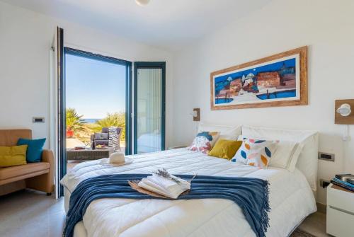 a bedroom with a bed with a view of the ocean at Luxury Sunshine Villa in Alghero with pool and sea view in Alghero