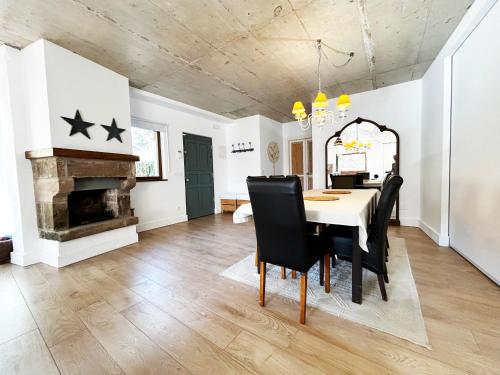 a dining room with a table and chairs and a fireplace at La casa de Cabuérniga in Cabuerniga